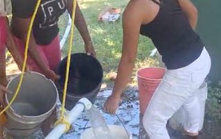 Women filling buckets from new water well.